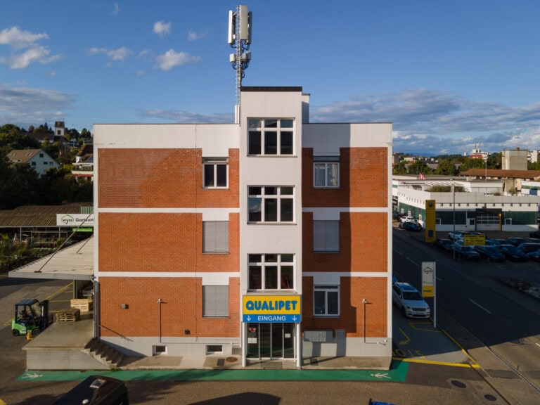 Ein dreistöckiges weißes Backsteingebäude mit einem 